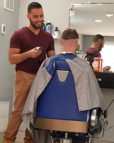 Barber at work behind seated client